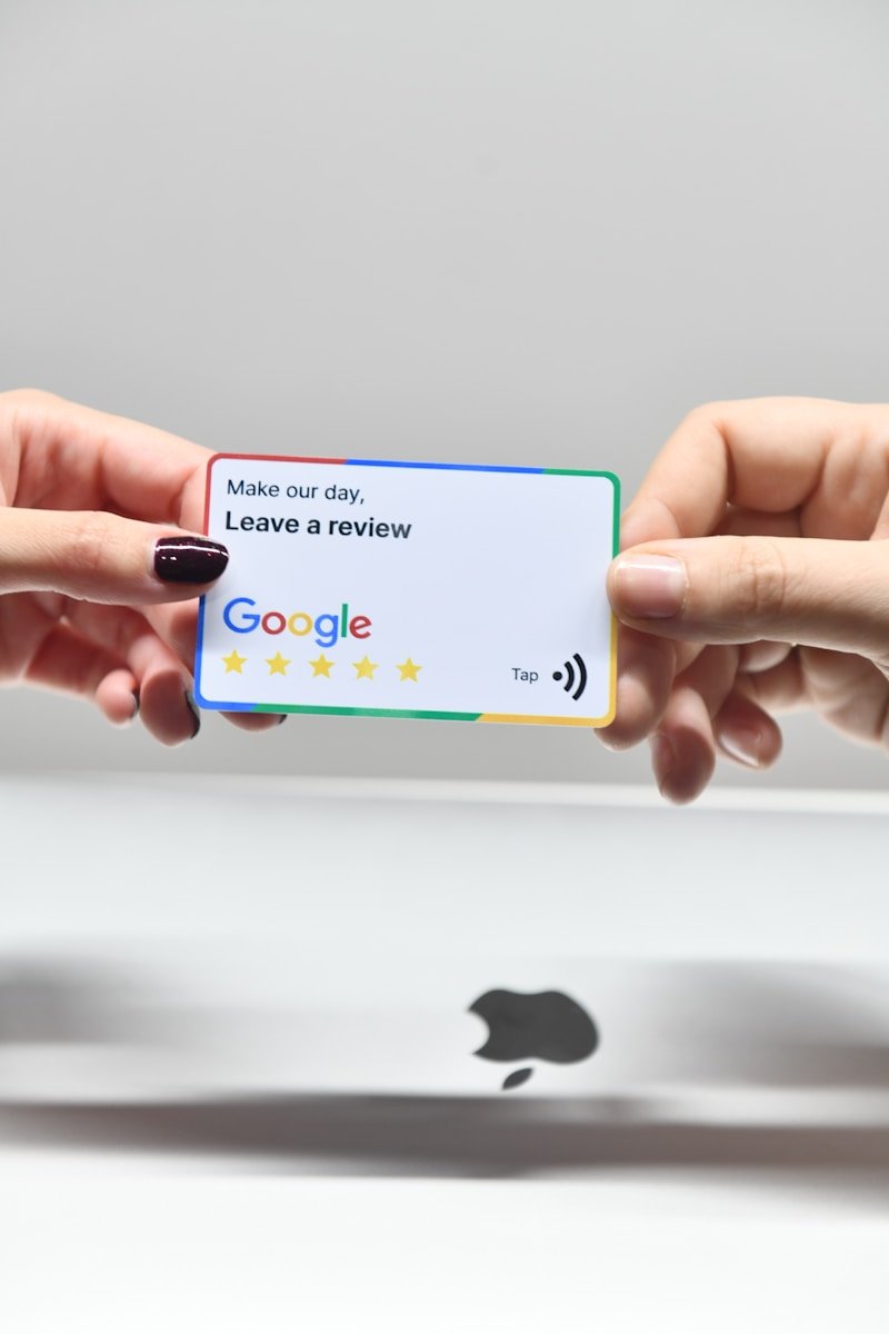 Gestión reseñas online restaurantes- two hands holding a google credit card in front of an apple logo