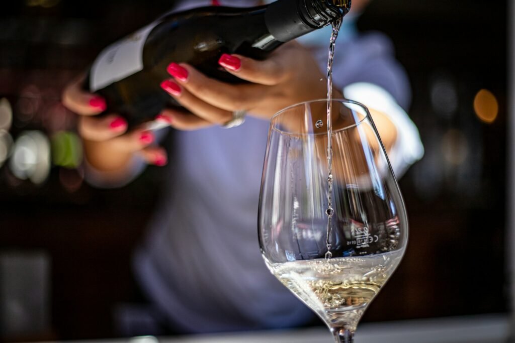 Cultura de Servicio al Cliente en Restaurantes de EE.UU. - a woman pouring a glass of wine into a wine glass