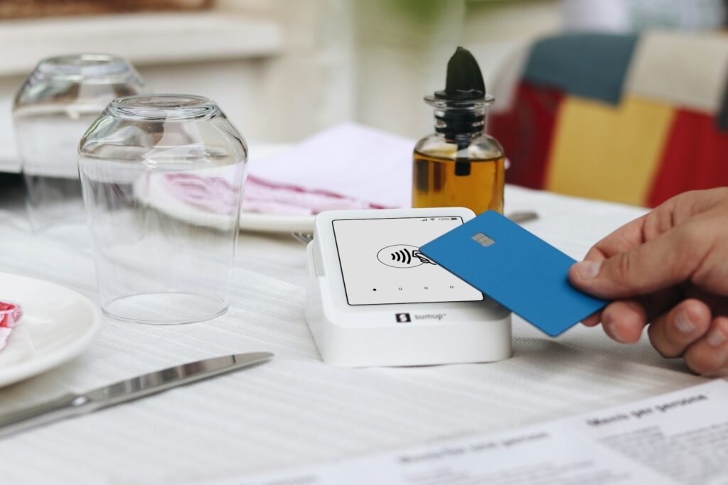 Cultura de Servicio al Cliente en Restaurantes de EE.UU. - A person holding a credit card at a table