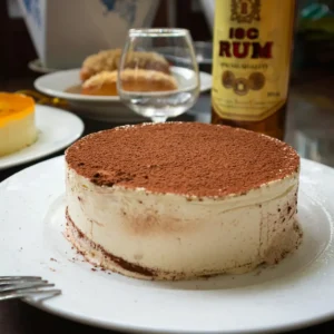 Cheesecake con cacao espolvoreado por encima y vino